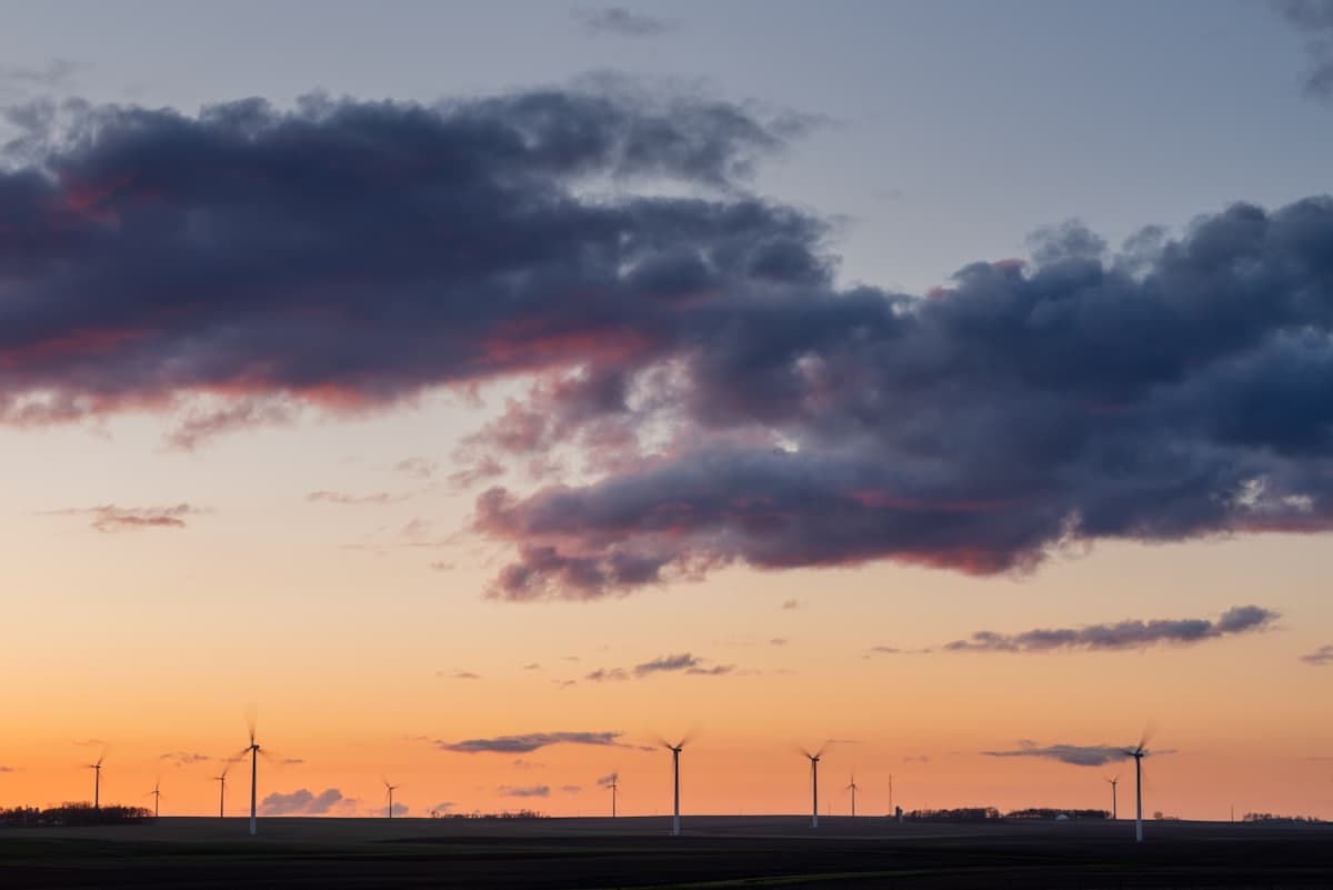 Wind turbines silhouetted against a sunset sky