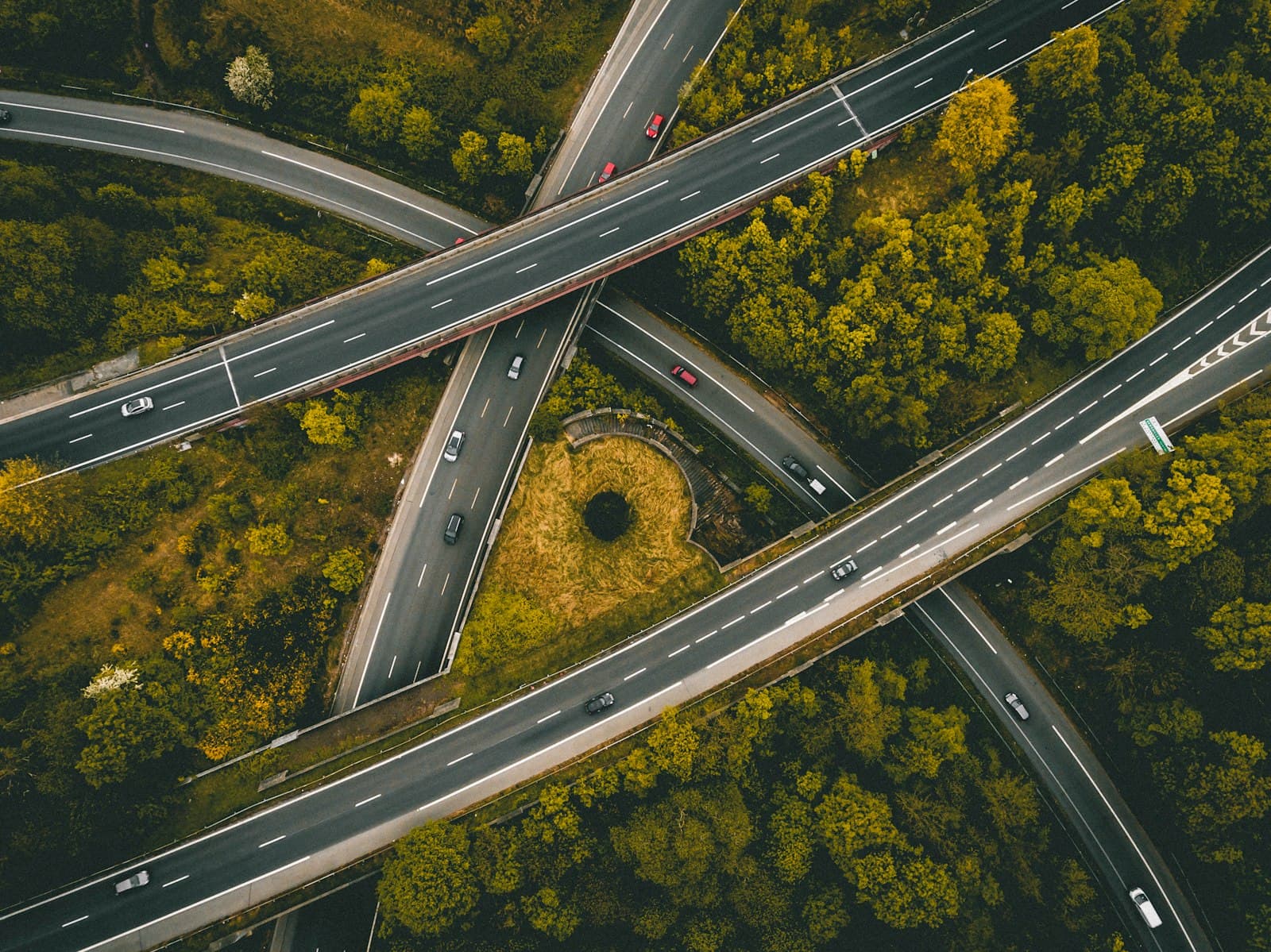 Aerial view of interlocking motorways through green woodland